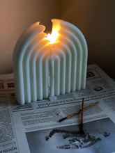 Load image into Gallery viewer, Lit sculptural white candle with arch design on newspaper with incense.