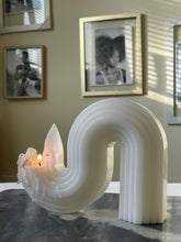 Load image into Gallery viewer, Curved white sculptural candle lit at one end on marble surface indoors